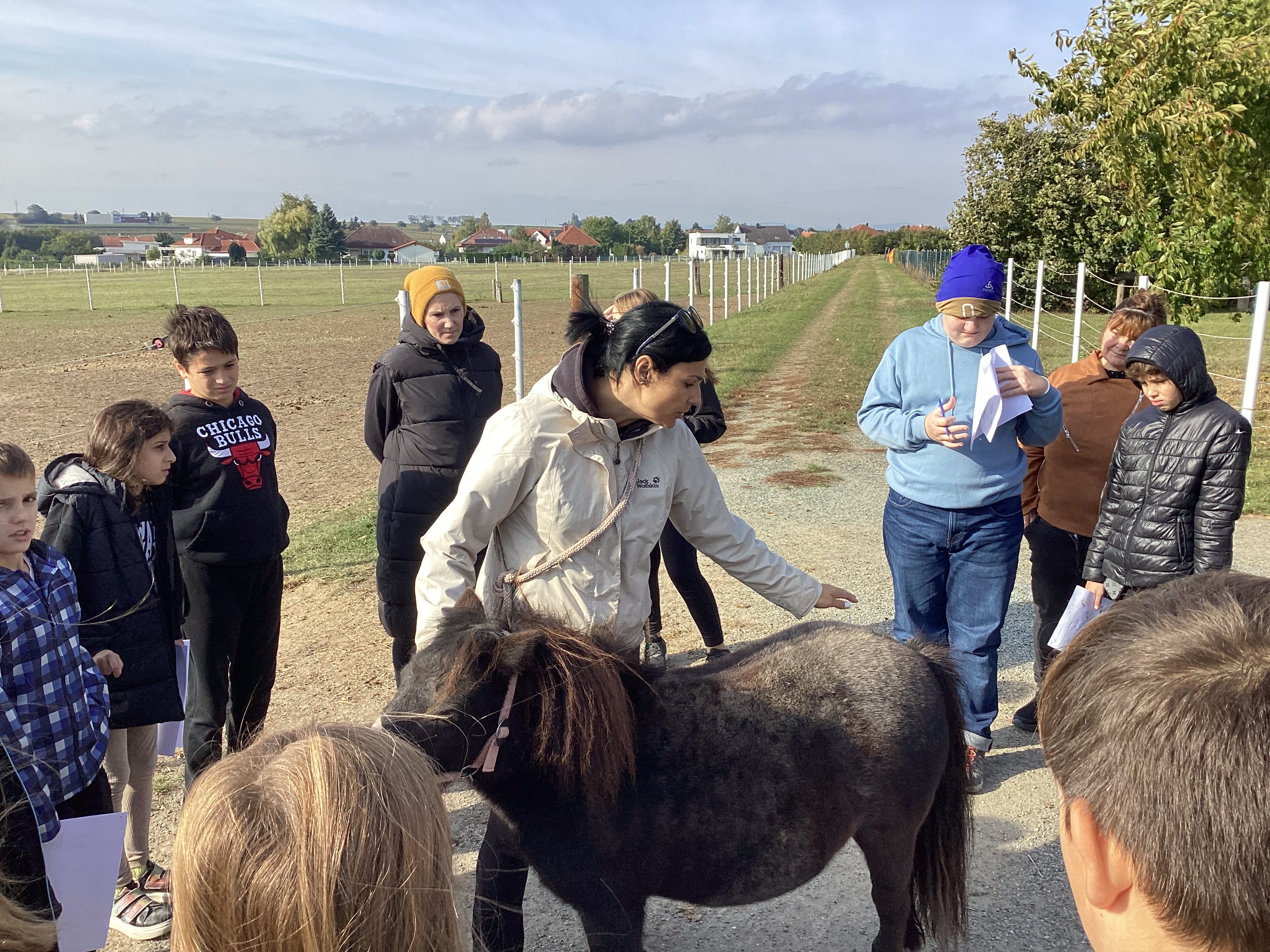 Biologieunterricht am Schlossgrundhof Deutschkreutz. Lehrkraft steht mit den Schülerinnen vor einem Pony und beschreibt die Körperteile.